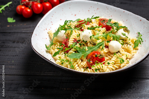 Caprese salad Pasta with tomato, mozzarella vegetable on a dark background, Restaurant menu, dieting, cookbook recipe top view