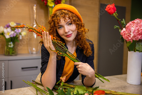 Ginger long-haired girl with flowers looking romantic photo