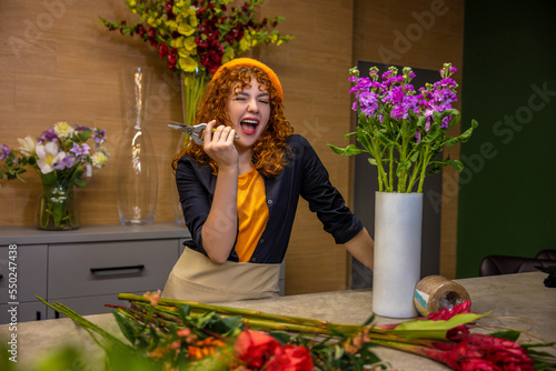 Florist preparing flowers for bouquets and looking involved photo