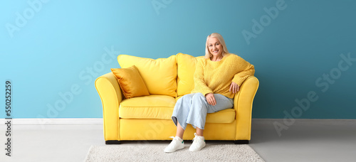 Mature woman sitting on sof...
