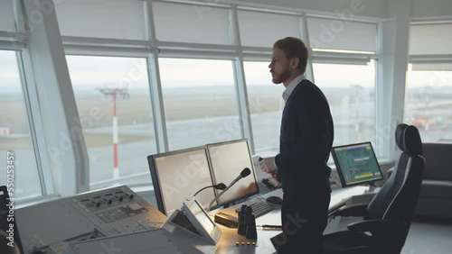  Air traffic controller make announcement on phone in the control tower. Realtime photo