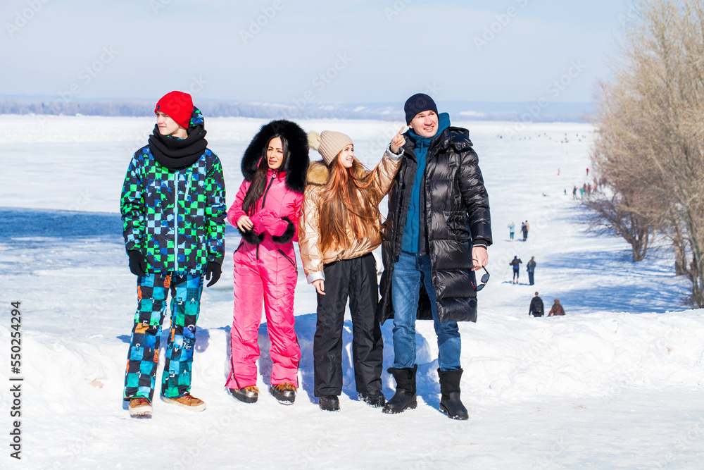 Young family of four walking outdoors in winter