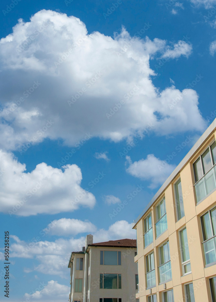 Vertical White puffy clouds Two low rise buildings with glass panels at La Jolla, California Vertical White puffy clouds Two low rise buildings with glass panels at La Jolla, California