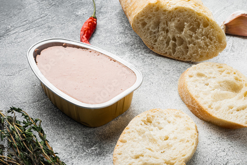 Fresh chicken liver pate from can on bread, on gray stone table background photo