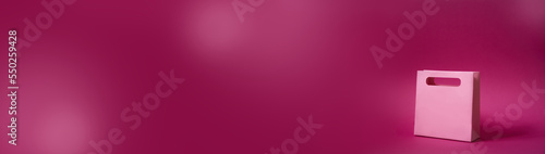 sale concept. Shopping bag isolated on pink plain neutral background, christmas gift valentines day birthday girl presents, black friday, cyber monday. Extra wide banner , copy space, shop, center,buy