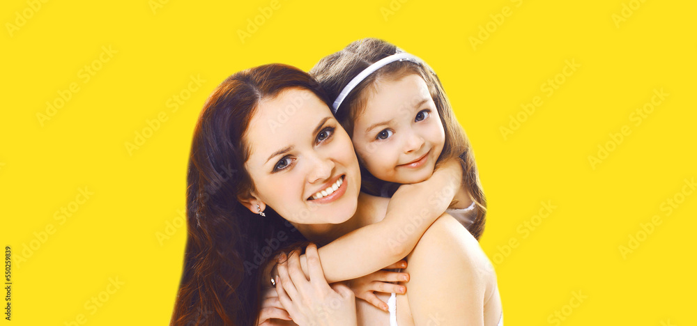 Portrait of happy smiling mother with daughter child on yellow background Portrait of happy smiling mother with daughter child on yellow background