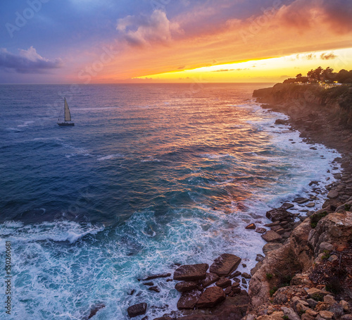 Print op canvas Red colorful sunset and vivid dramatic sky at rocky shore of the Atlantic ocean
