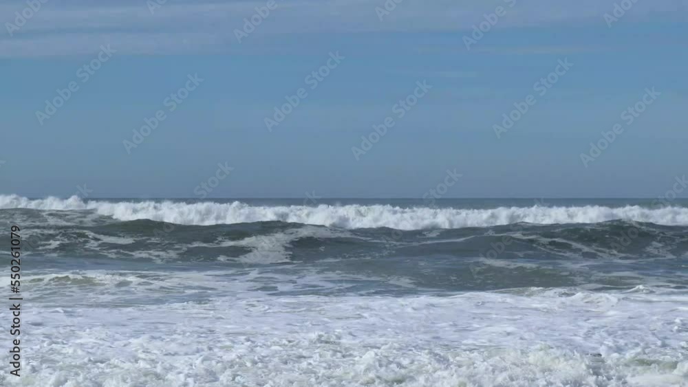 Medium waves crashing against shoreline and beach in Portugal Medium waves crashing against shoreline and beach in Portugal