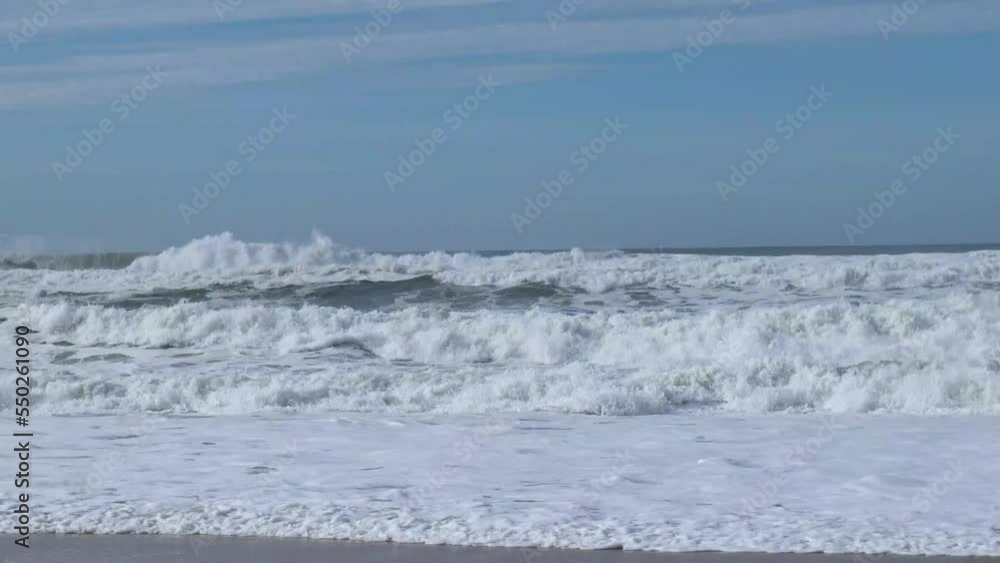 White capped waves crashing at shoreline on the beach in Nazare, Portugal White capped waves crashing at shoreline on the beach in Nazare, Portugal