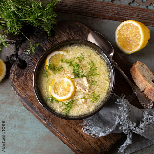 bowl with traditional greek chicken soup with egg and lemon on the table photo