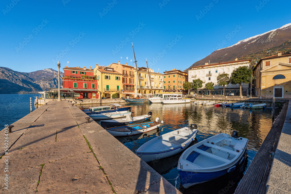 Malcesine village. Port with small boats and ferries moored and colorful houses. Famous tourist resort on the coast of Lake Garda (Lago di Garda). Verona province, Veneto, Italy, southern Europe. Malcesine village. Port with small boats and ferries moored and colorful houses. Famous tourist resort on the coast of Lake Garda (Lago di Garda). Verona province, Veneto, Italy, southern Europe.
