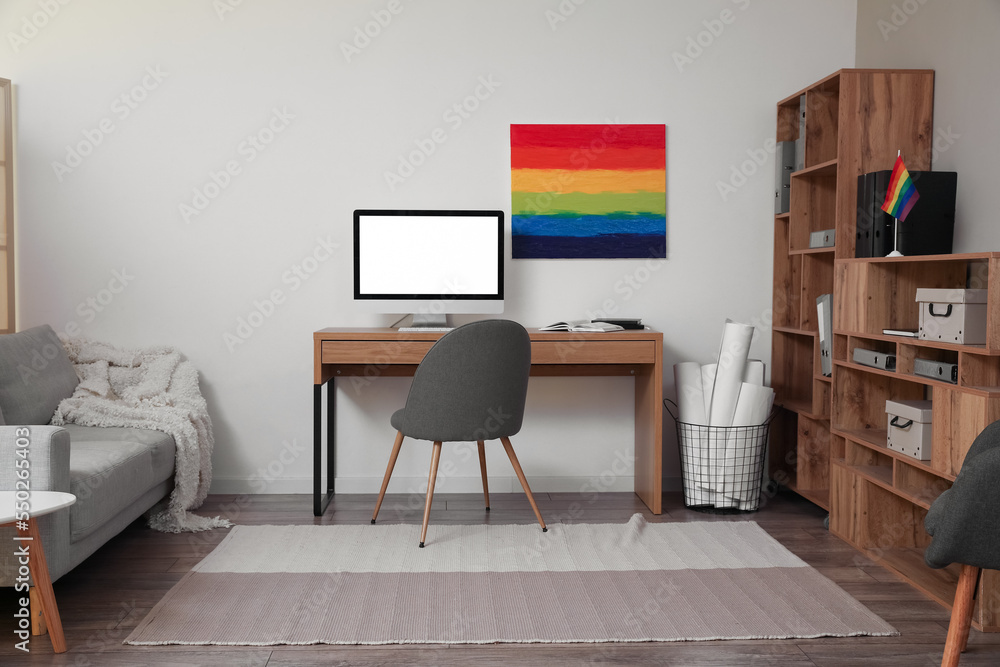 Interior of modern office with workplace, LGBT flag and painting Interior of modern office with workplace, LGBT flag and painting