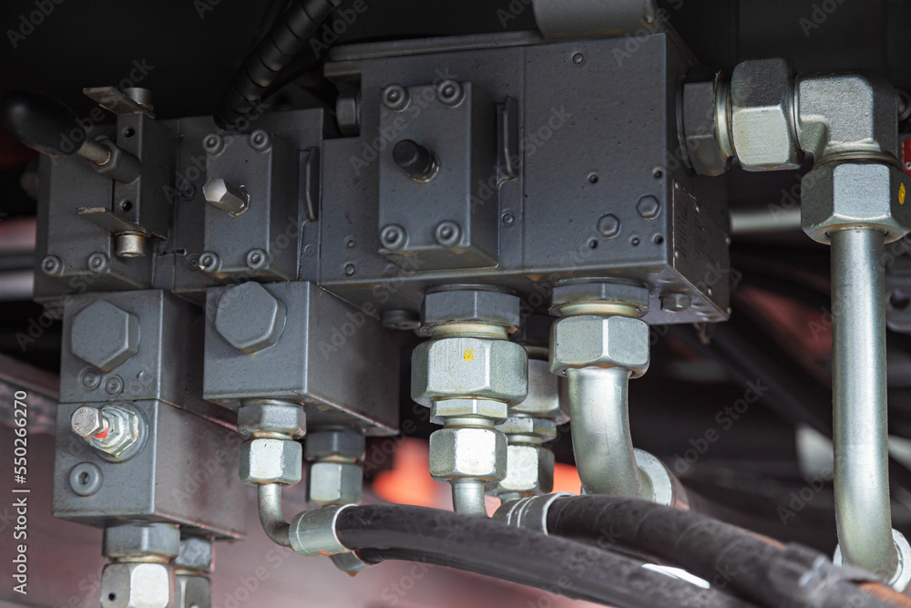 High pressure hydraulic hose system connected with steel pipes and connected to the system, close-up. Hydraulics of a large truck crane. High pressure hydraulic hose system connected with steel pipes and connected to the system, close-up. Hydraulics of a large truck crane.