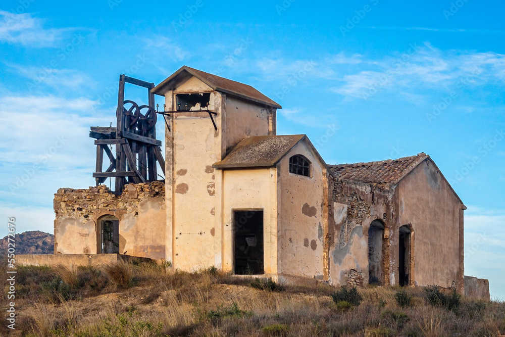Ruins of a desolated mine with derrick and miners' buildings, Mazarron, Spain