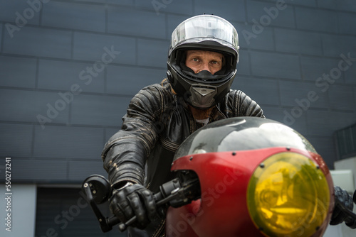 Biker rides a motorcycle and looks forward © uladzislaulineu
