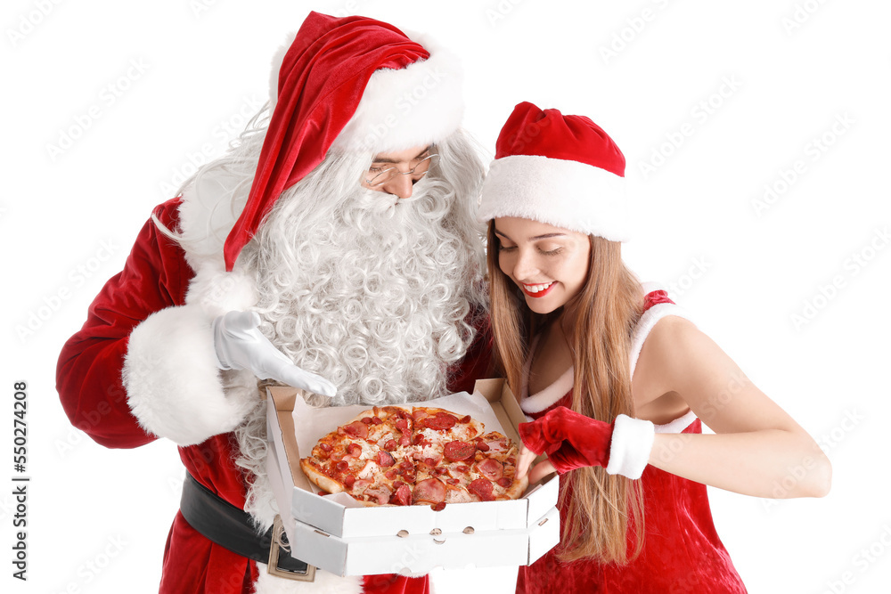 Young couple in Santa costumes holding box with tasty pizza on white background Young couple in Santa costumes holding box with tasty pizza on white background
