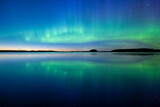 Northern lights dancing over lake in Farnebofjarden national park in north of Sweden.