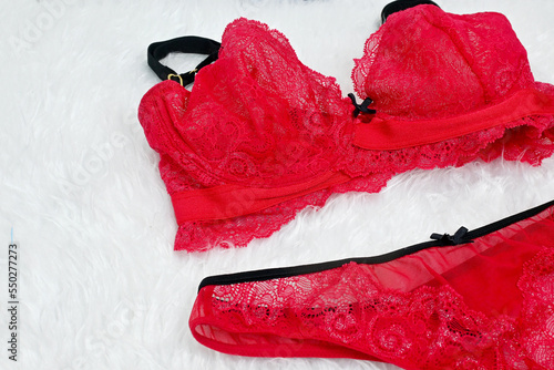Sexy glamorous red lace lingerie, Sexy lace red glamours lingerie with red ribbon decoration on white fur background, woman shopping and fashion female wardrobe concept. Woman accessories.