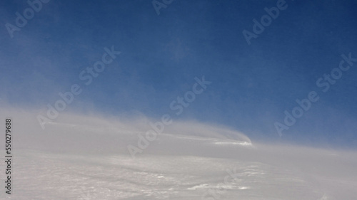 Winter mountain landscape. Snowstorm. Strong wind raises snow over the mountain slope. © Oleksiy