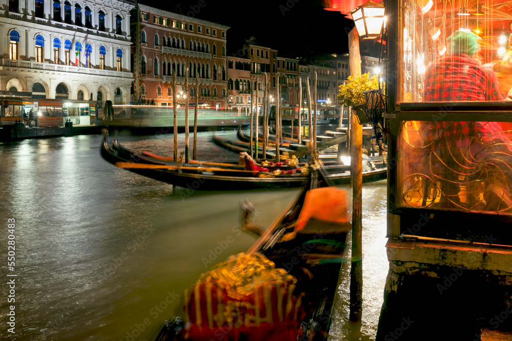 Venezia. Gondole e scia di vaporetto sul Canal Grande, a Rialto di notte