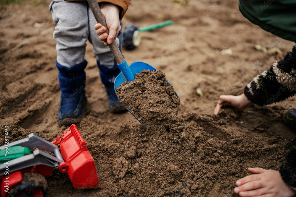 Brothers building a castle in sand.