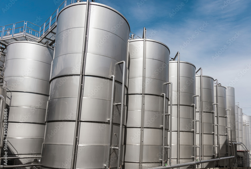 Steel tanks for wine fermentation at a modern winery. Large brewery silos for barley or beer Steel tanks for wine fermentation at a modern winery. Large brewery silos for barley or beer