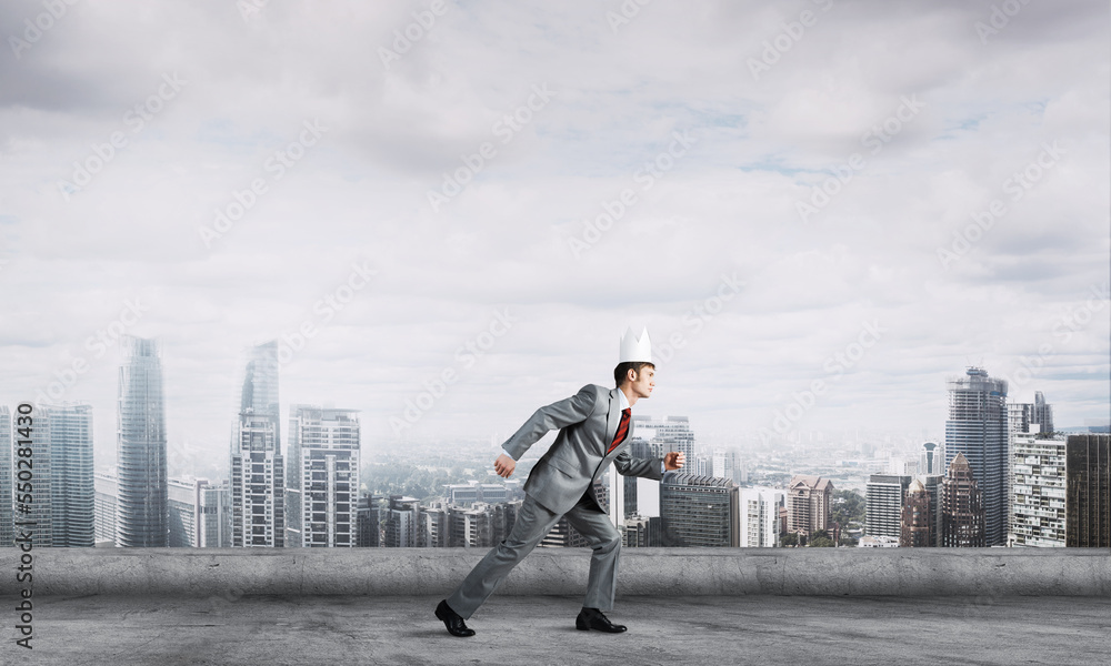 King businessman in elegant suit running on building roof and business center at background King businessman in elegant suit running on building roof and business center at background