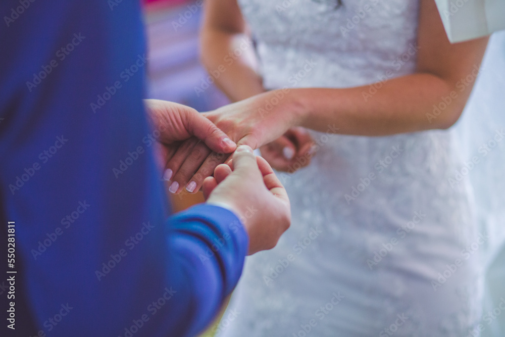 groom putting wedding ring on bride's hand at a wedding
