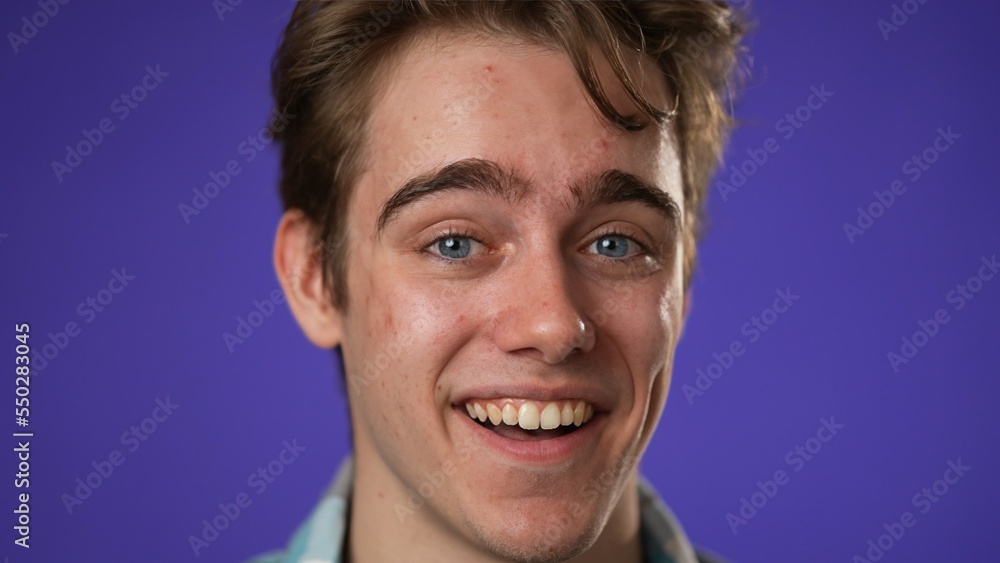 Fototapeta premium Closeup portrait of laughing smiling, happy, handsome young hipster man 20s isolated on purple color background in studio. Sincere emotions lifestyle concept.