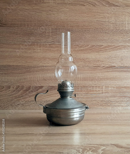 Vintage kerosene lamp lantern on wooden table over grunge background