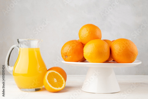 Orange juice with with oranges on white wooden table © Jakub