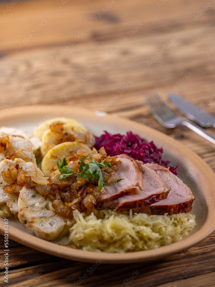 smoked meat served with red and white cabbage and two kinds of dumplings smoked meat served with red and white cabbage and two kinds of dumplings