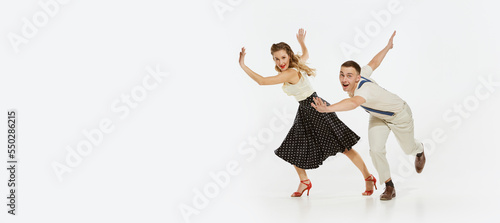 Dynamic portrait of happy, stylish and energetic dancers dancing lindy hop or swing dance isolated on white background. Music, energy, happiness, mood, action