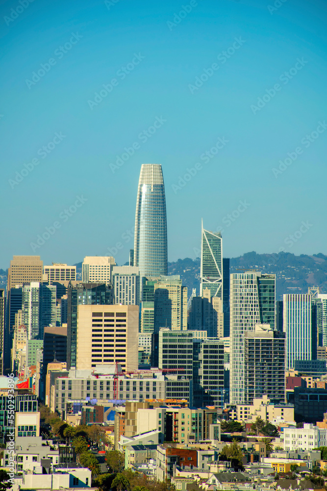 Obraz premium Downtown sky scrappers in late afternoon sun in the historic districts of san francisco california with buildings and mountains