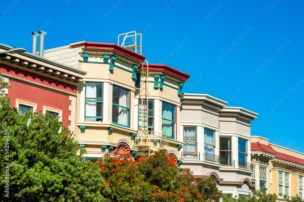 Row of historic houses in the downtown districts of San Francisco California in late afternoon sun with clear blue sky background