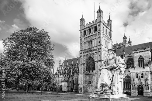 Exeter, Devon, England, UK: Statue of Richard Hooker (1553 - 1600) in front of Exeter Cathedral, the Cathedral Church of Saint Peter in Exeter in black and white