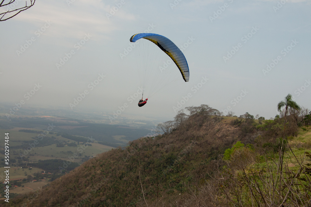 man flying a paraglider in a natural landscape man flying a paraglider in a natural landscape