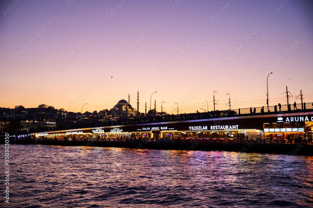 sunset in istanbul, galata bridge looks great at sunset. passenger ship