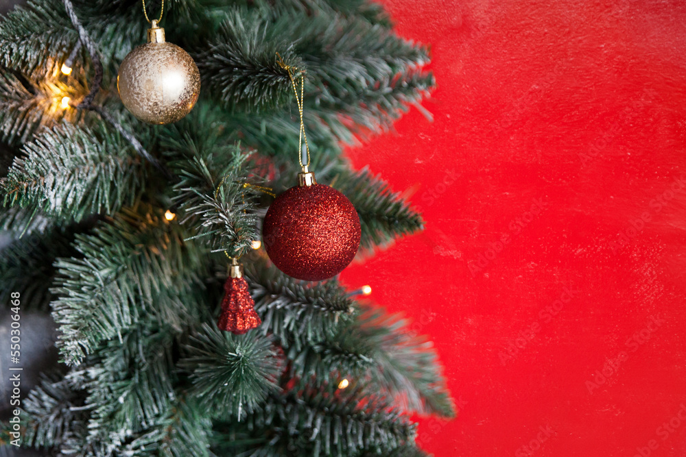 Christmas border branches of fir tree with decoration and red wall background Christmas border branches of fir tree with decoration and red wall background