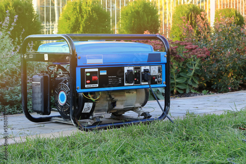 Foto Power generator standing in the garden on the pavement