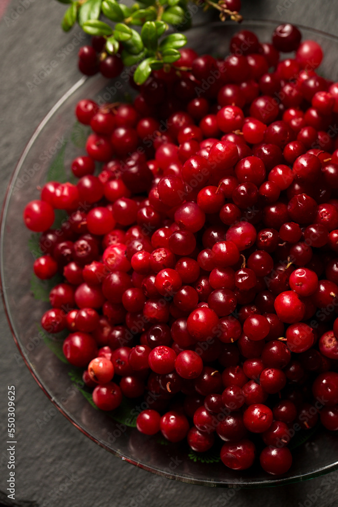 Delicious fresh lingonberry berries on a stone board Delicious fresh lingonberry berries on a stone board