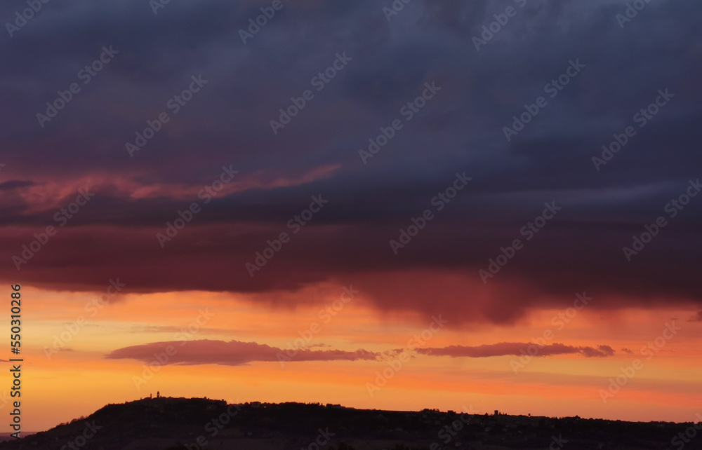 Rosso tramonto sul paese sopra la collina Rosso tramonto sul paese sopra la collina
