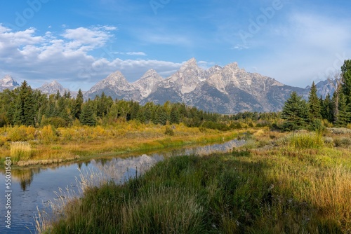 Rvier flowing in a green field with hills on the background in the Grand Teton national park,Wyoming photo