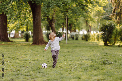 cute little boy play a football outdoors