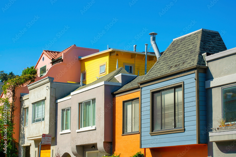 Row of modern colorful houses or homes in the historic districts of san francisco california with blue sky and visible windows