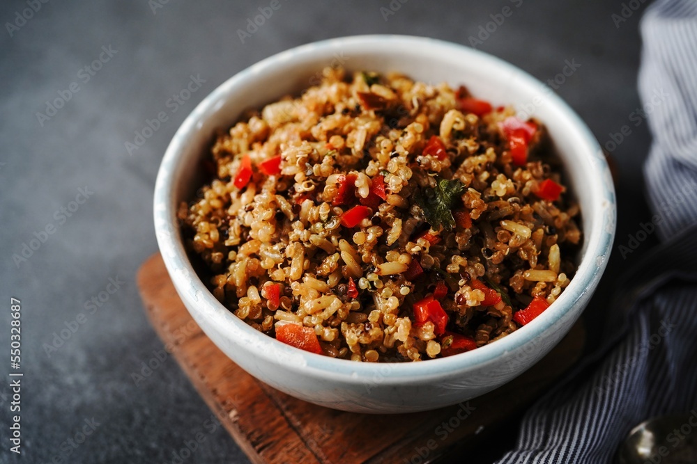 Quinoa brown rice pulao with red pepper served in a bowl- healthy eating concept Quinoa brown rice pulao with red pepper served in a bowl- healthy eating concept