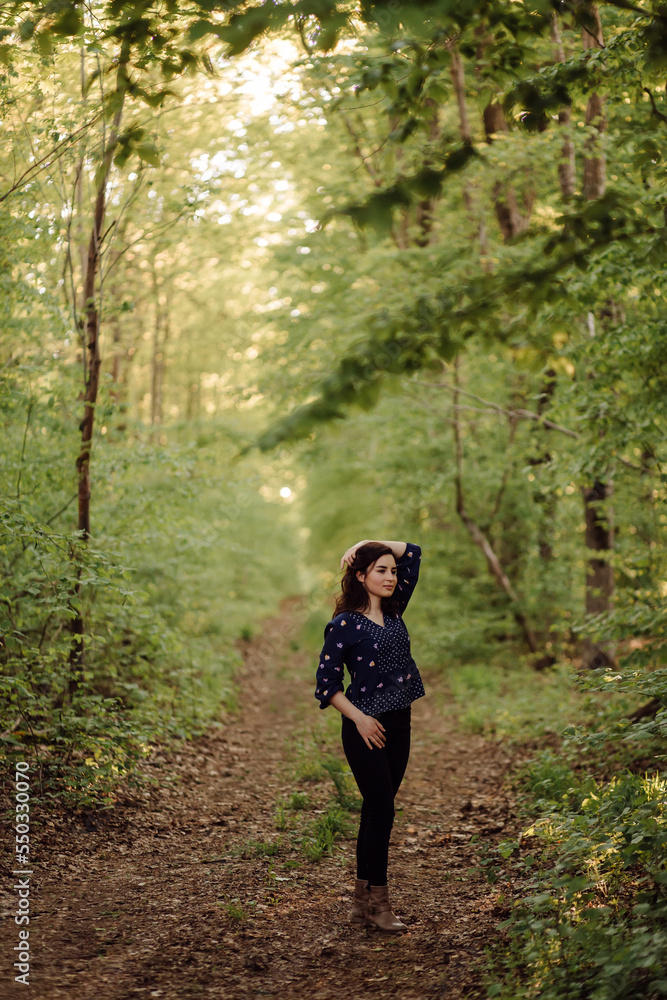 A beautiful young woman walking in the forest A beautiful young woman walking in the forest
