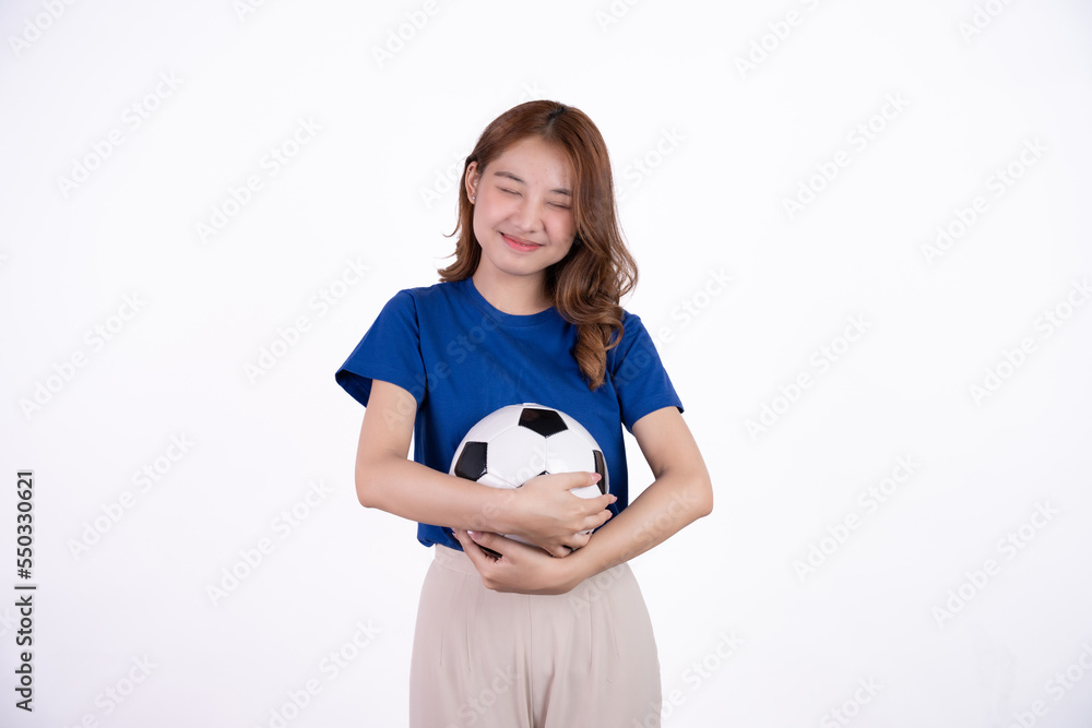 Asian woman smiling in blue t-shirt holding football to cheering the soccer game isolated on white screen background. Asian woman smiling in blue t-shirt holding football to cheering the soccer game isolated on white screen background.