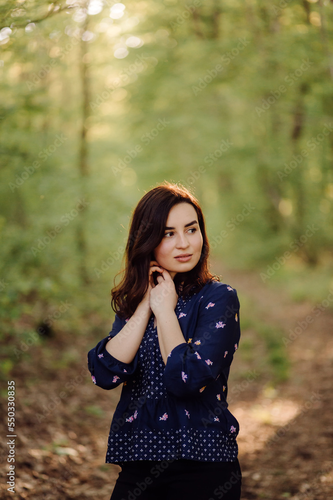 A beautiful young woman walking in the forest A beautiful young woman walking in the forest
