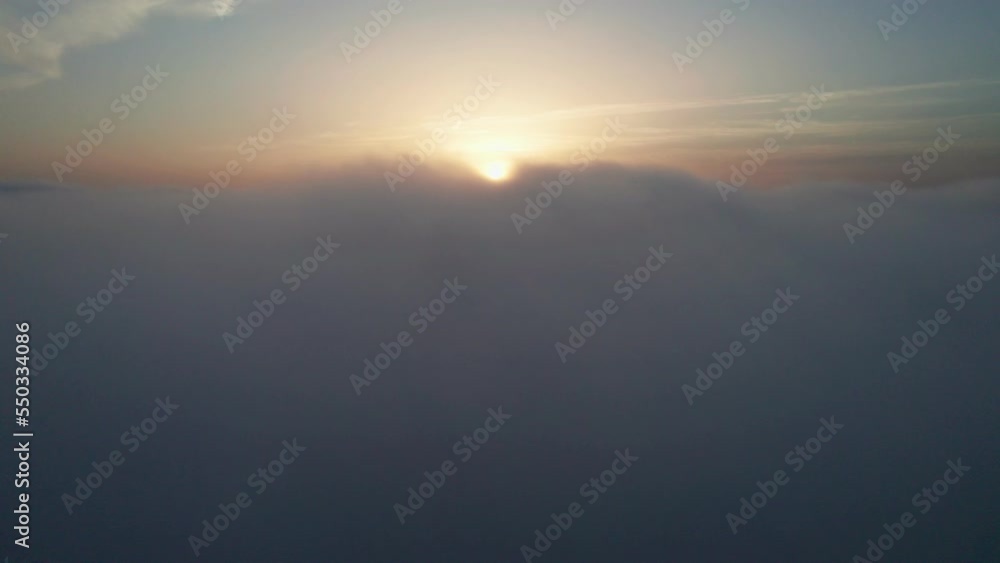 View from the cockpit of an airplane above the clouds at sunrise. View from the cockpit of an airplane above the clouds at sunrise.